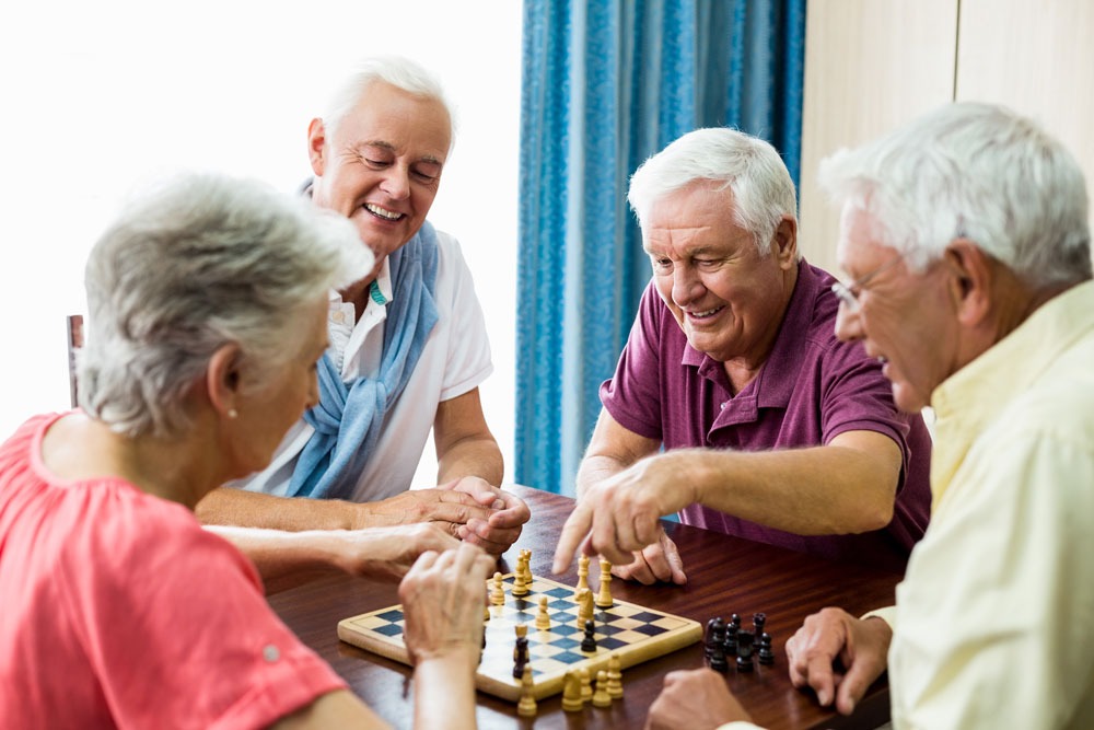Senioren fröhlich zusammen beim Schachspielen